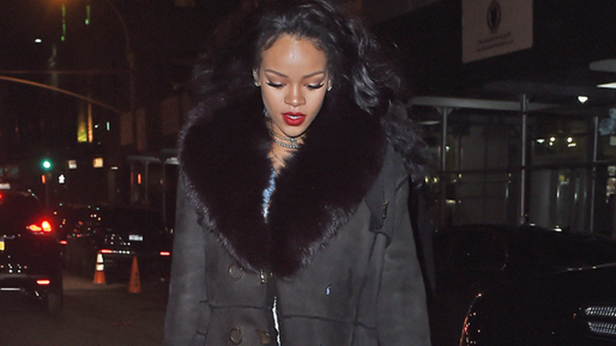 Rihanna värmer sig i en lång kappa i New York. 