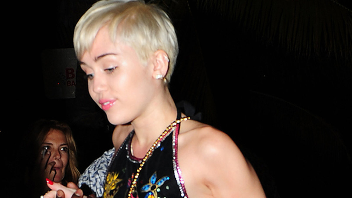 Miley Cyrus matchar sina jeansshorts med en top från Margiela.