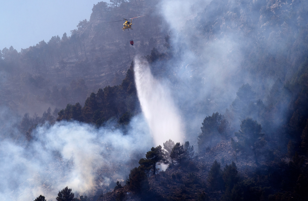 En helikopter som förra helgen släppte vatten över en skogsbrand nära Castellon de la Plana, i östra Spanien där bränderna nu är under kontroll. Arkivbild.