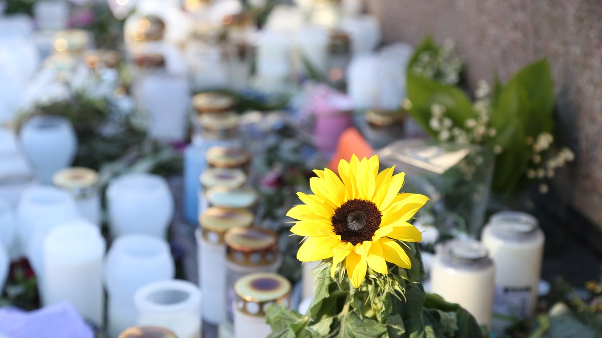 Blommor och ljus som ställts ut för att hedra Lisa Holms minne. 