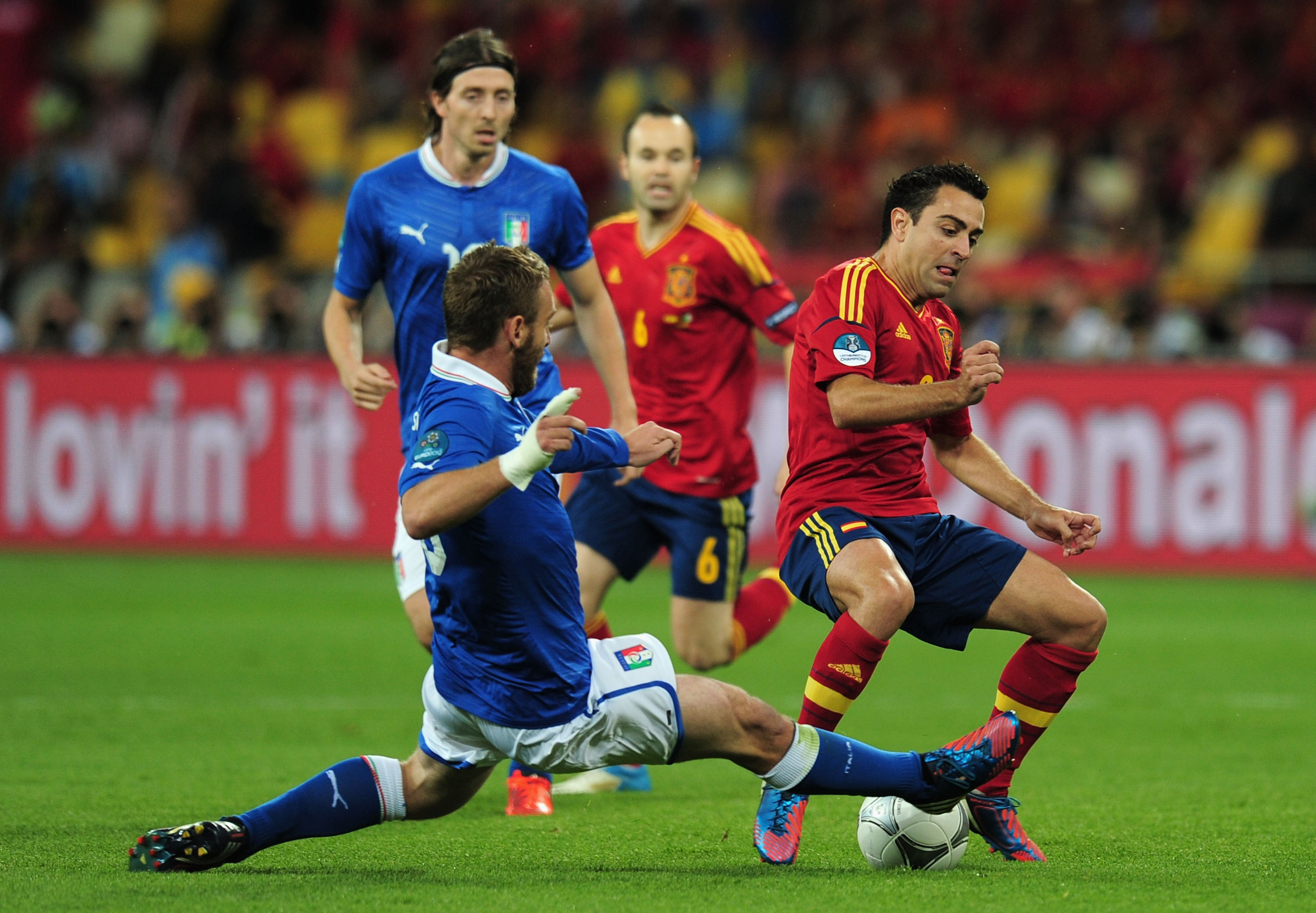 De Rossi tacklar Xavi. De Rossi tacklar Xavi.