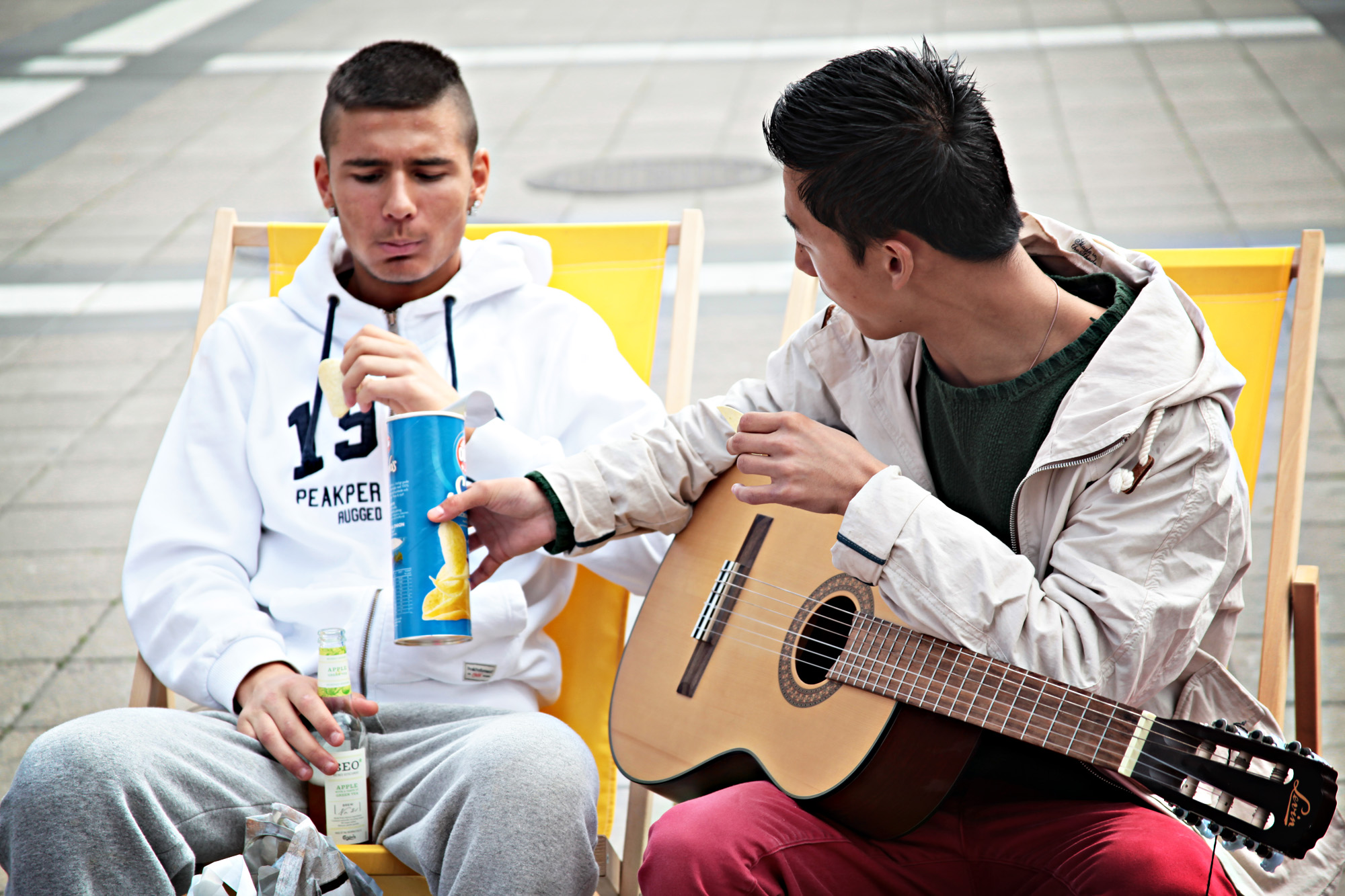Två killar som underhåller varandra med gitarr och chips.