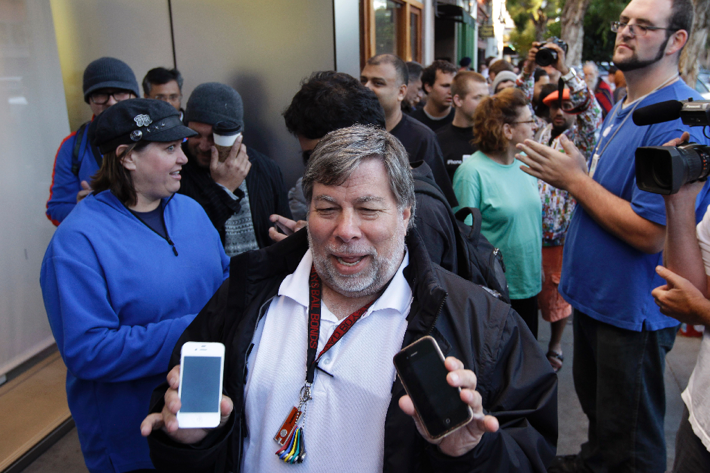 Hans kollega Steve Wozniak visar upp samma modell medan han köar för att få köpa nya iPhone 4S.