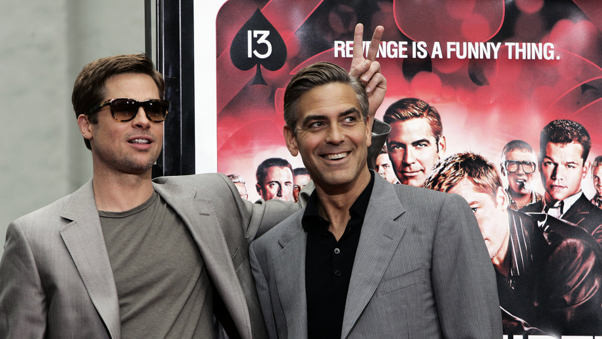 Brad Pitt och George Clooney inför premiären av 'Ocean's 13.' Arkivbild.
