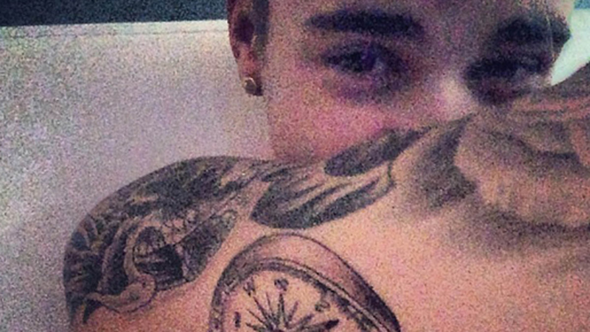 Justin Bieber visar sin nya tatuering.
