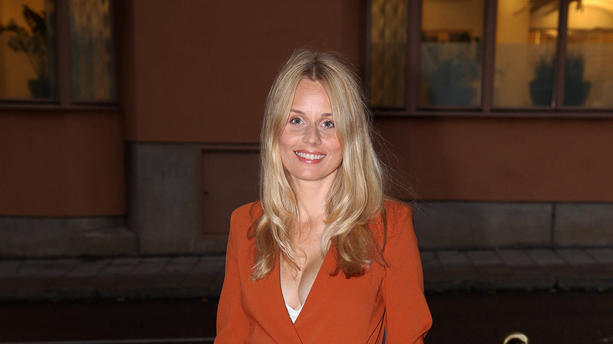 Skådespelerskan Helena af Sandeberg  i roströd kostym.