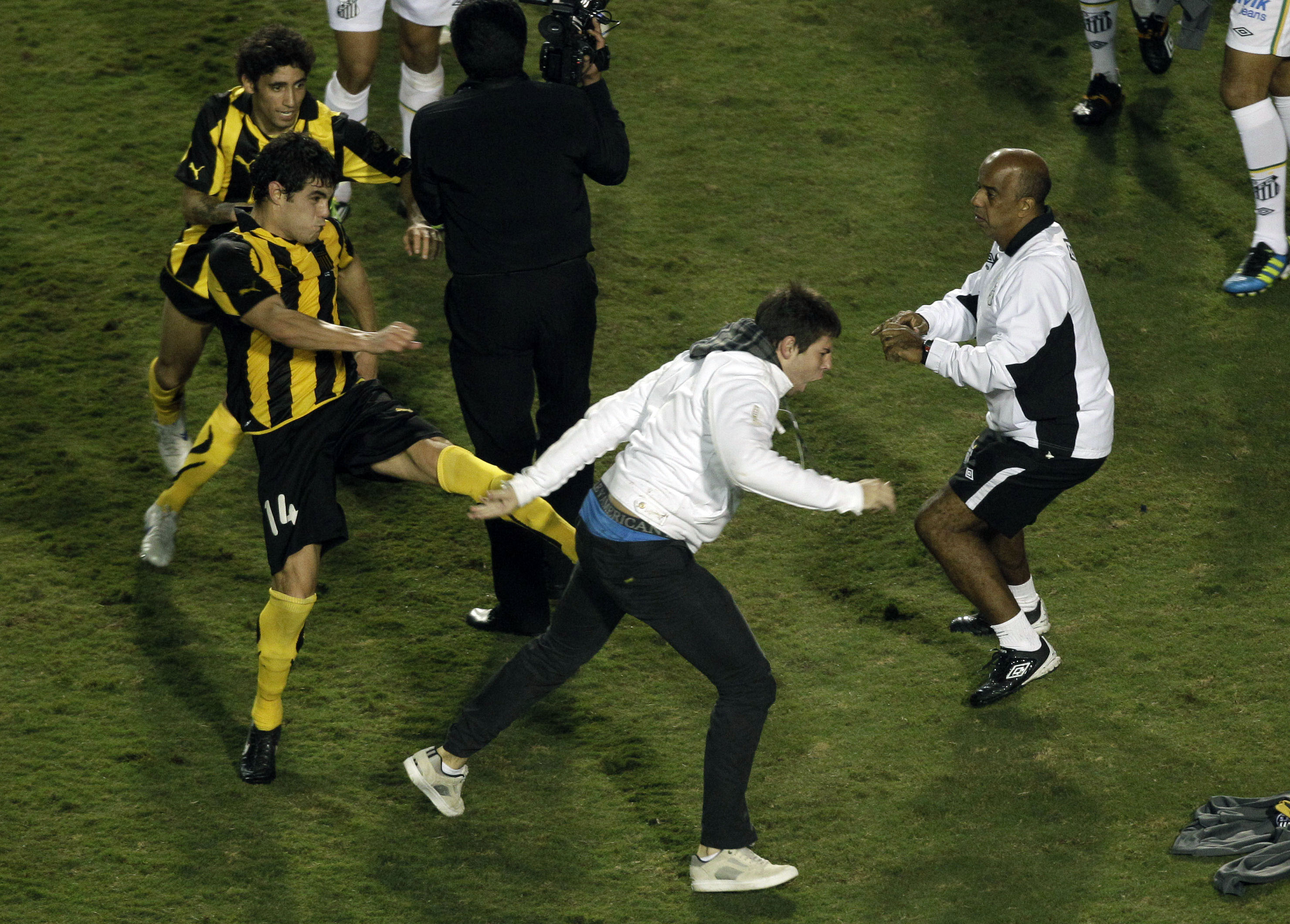 Till och med Santos fans tog sig in på plan för att vara med i slagsmålet. Här ses Luis Bernardo sparka mot en Santossupporter.