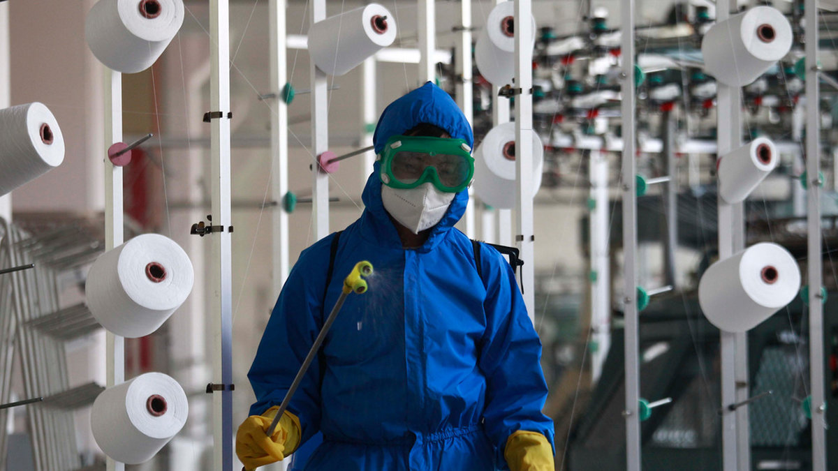 En anställd på en fabrik i Songyo-distriktet desinficerar arbetsgolvet i huvudstaden Pyongyang.