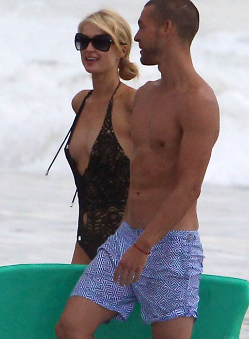Paris Hilton myser med en mystisk hunk på stranden. 