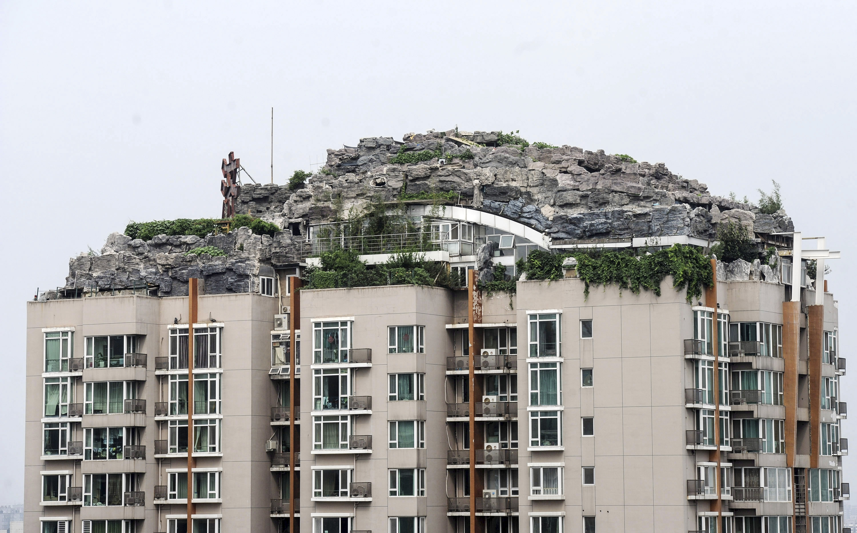 Bergstoppen i Beijing. Kinesiske Zhang Biqing, som bestämde sig för att bygga till denna skapelse på det existerande huset, är faktiskt redan en skurk bland grannarna. Han hade nämligen inget tillstånd. Sex år efter att han ändå lyckats få till sitt drömbygge revs det i december. Bergstoppen i Beijing. Kinesiske Zhang Biqing, som bestämde sig för att bygga till denna skapelse på det existerande huset, är faktiskt redan en skurk bland grannarna. Han hade nämligen inget tillstånd. Sex år efter att han ändå lyckats få till sitt drömbygge revs det i december.