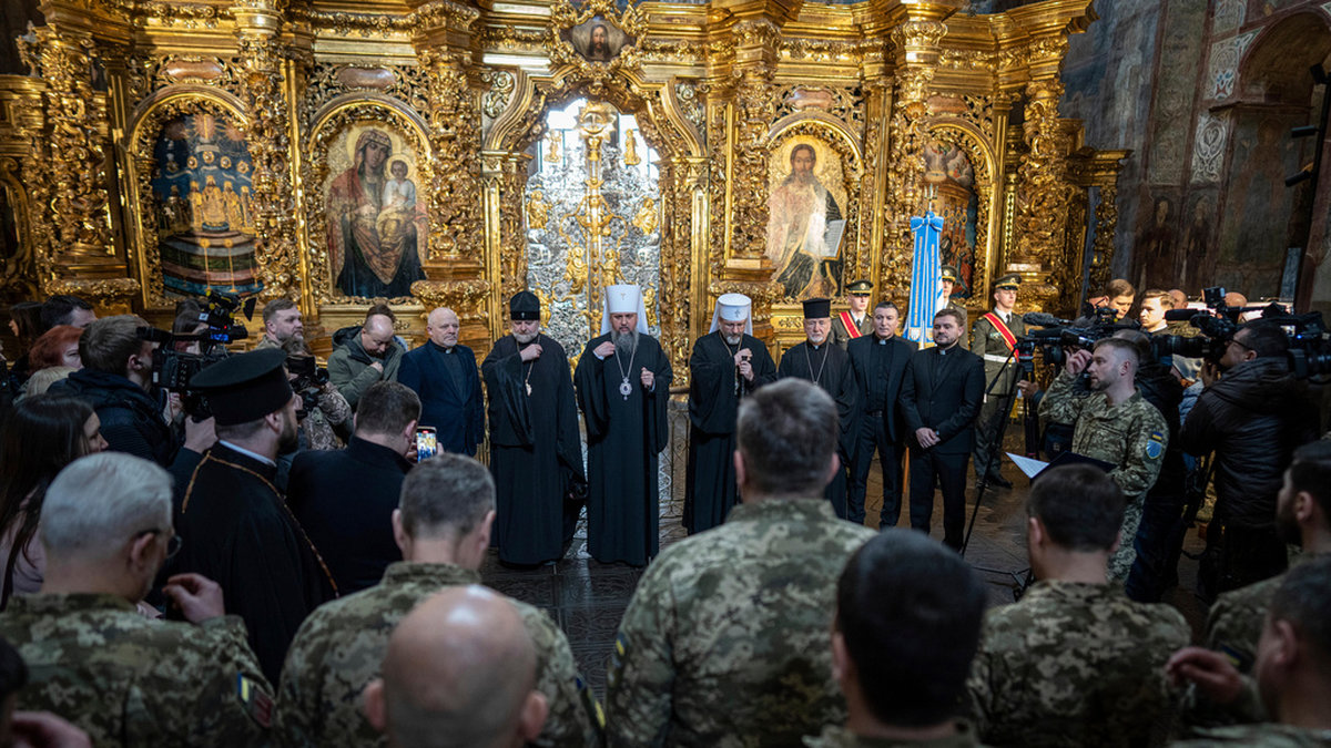 Ukrainska fältpräster mottar välsignelse i en officiell ceremoni där de godkänns att delta i strid.