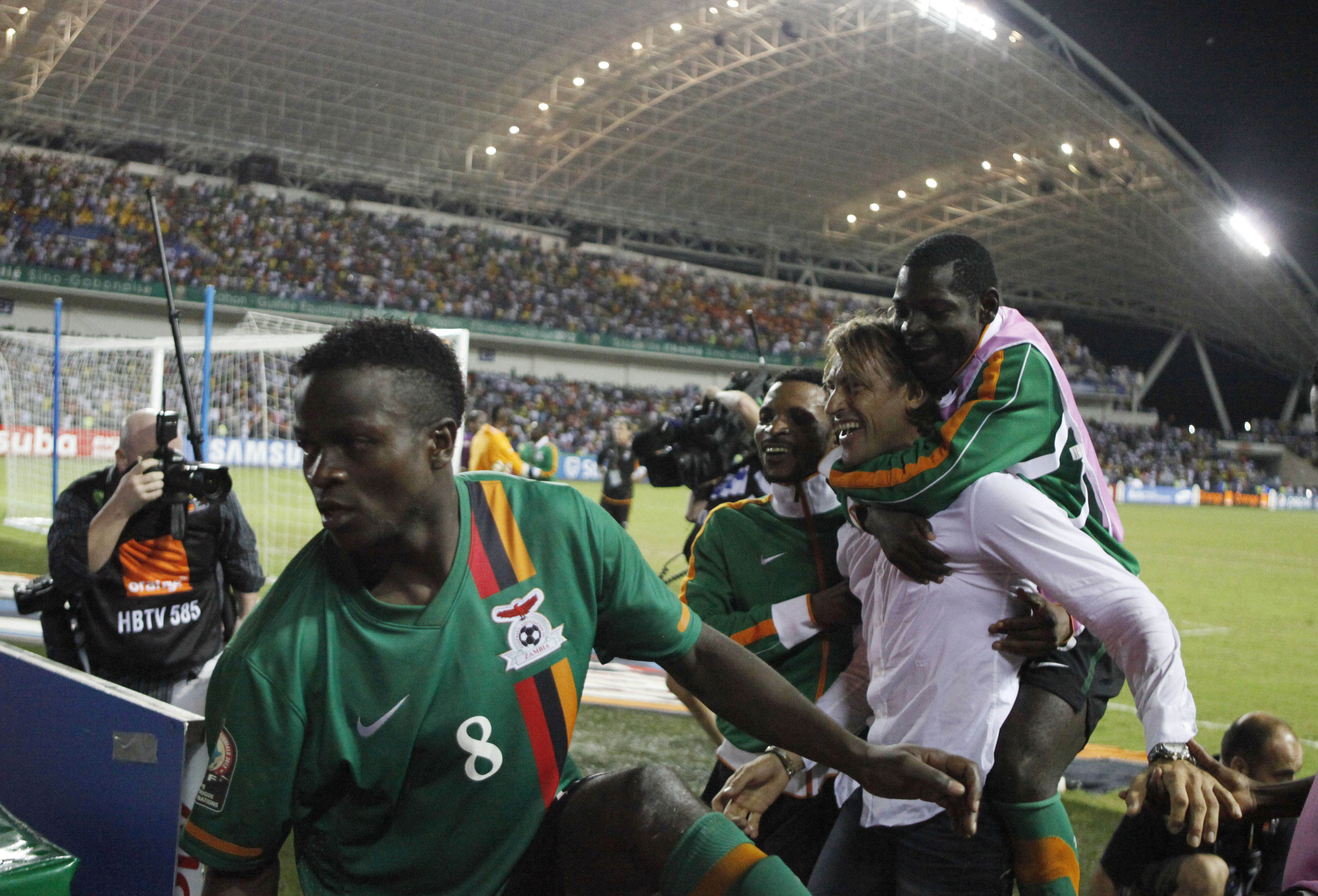 Zambia-coachen Herve Renard bär skadade spelaren Joseph Musonda till ceremonin.