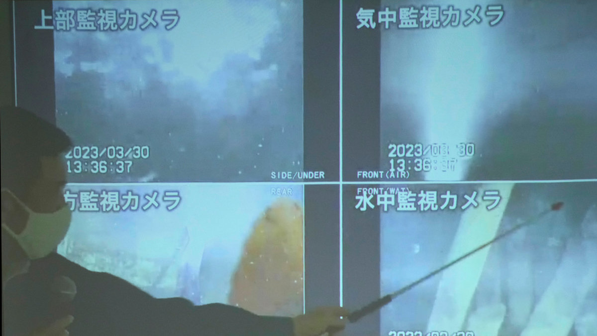 En talesperson för operatören Tepco visar de nytagna bilderna från kärnkraftverket Fukushima i Japan.