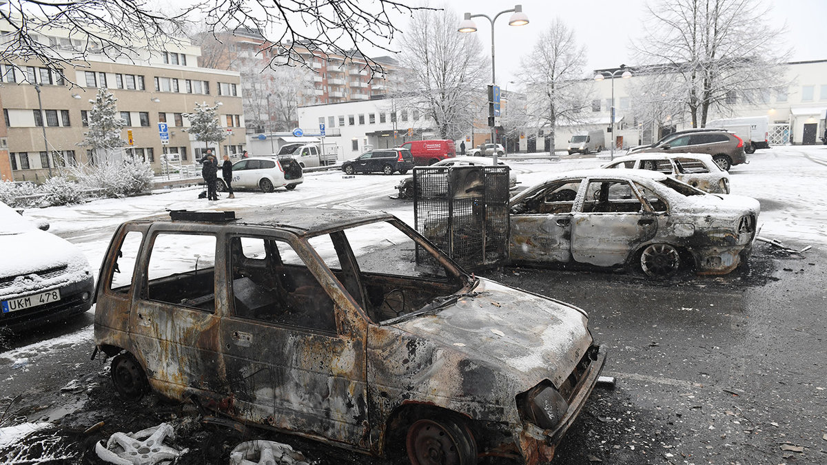 Brända bilar på en parkering i förorten Rinkeby utanför Stockholm.