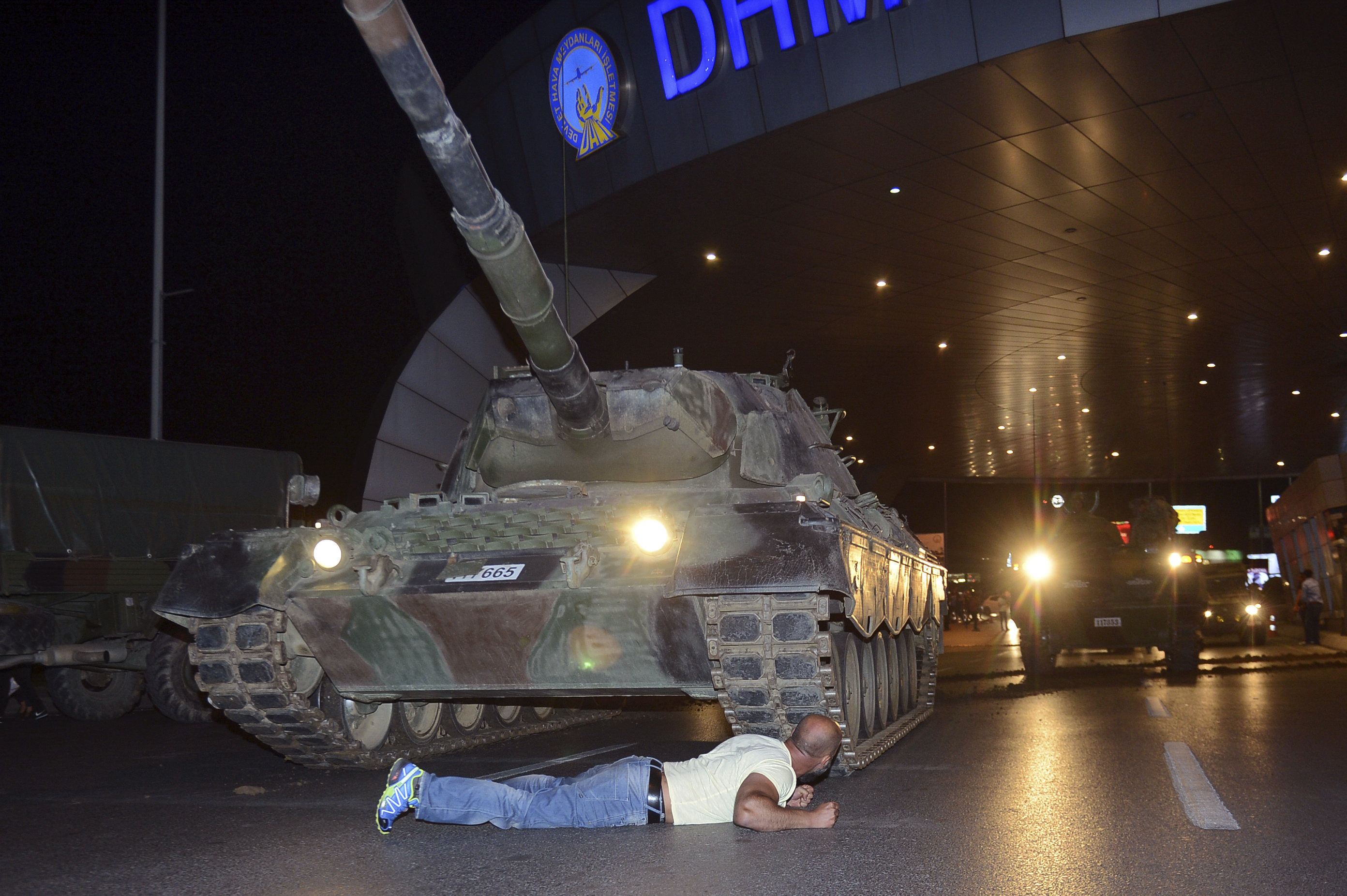 En man gömmer sig bakom en pansarvagn vid flygplatsen i Istanbul. En man gömmer sig bakom en pansarvagn vid flygplatsen i Istanbul.