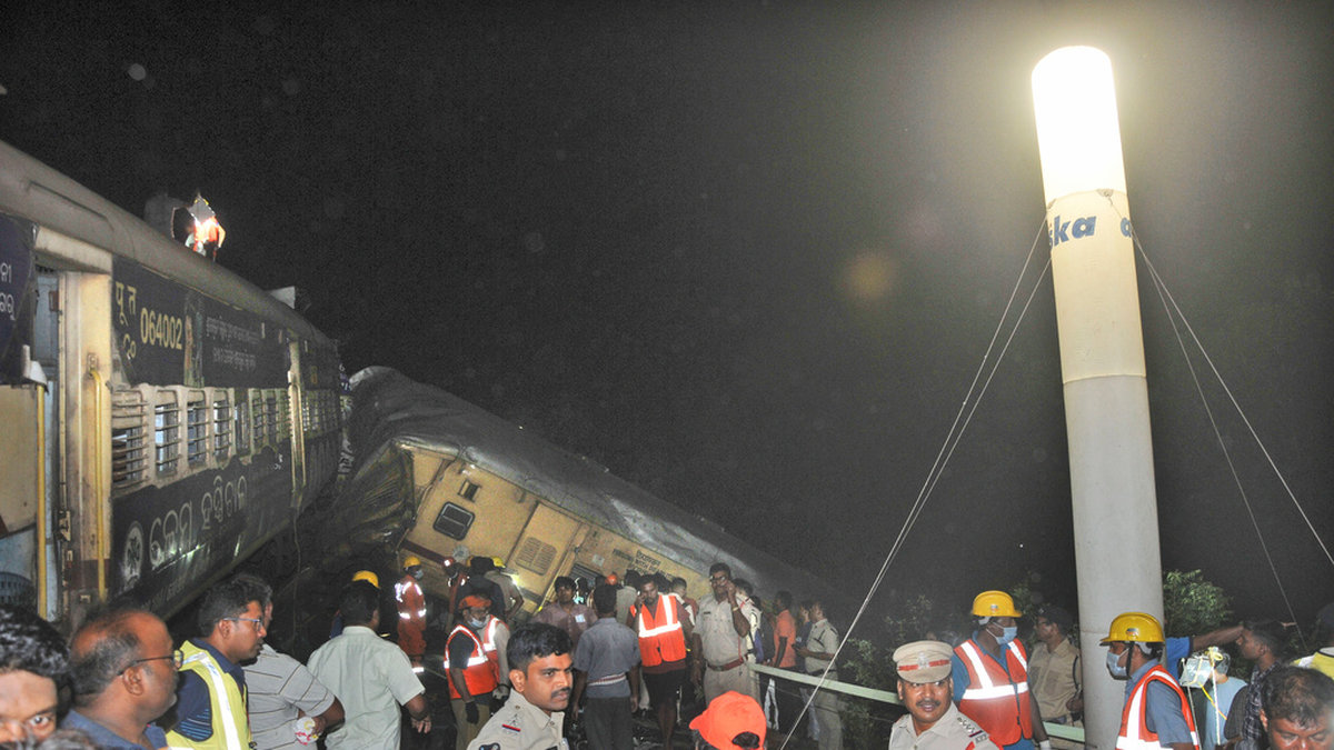Räddningsarbetare och andra vid olycksplatsen i Andhra Pradesh där 13 personer omkom och 50 skadades när två tåg kolliderade på söndagen.