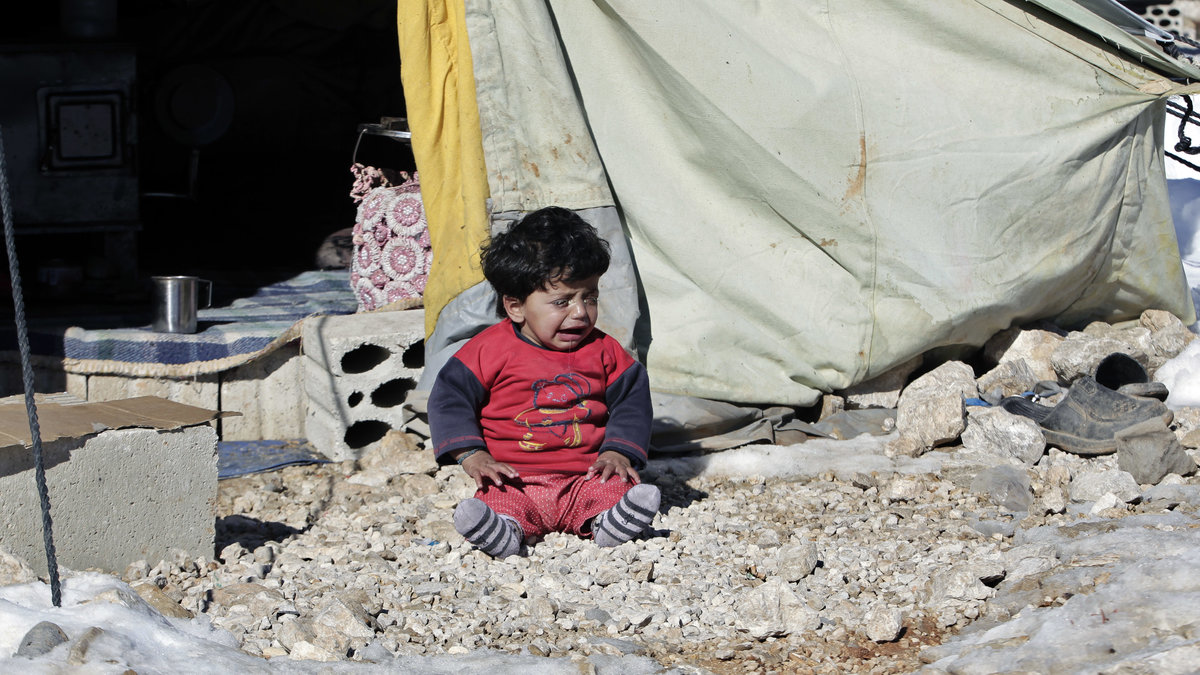 Ett syriskt barn gråter framför familjens tält i ett flyktingläger vid den libanesiska gränsen. 15 december 2013.