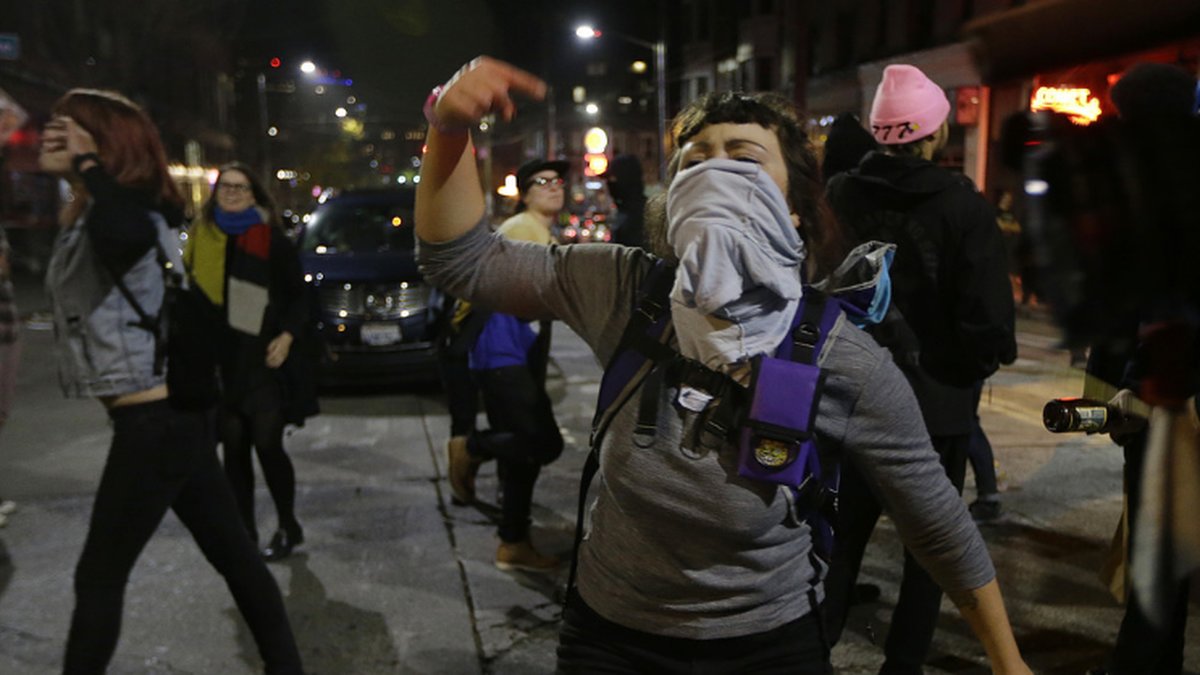 En arg demonstrant skriker upprört på Seattles gator över den nyvalda presidenten Donald Trump.