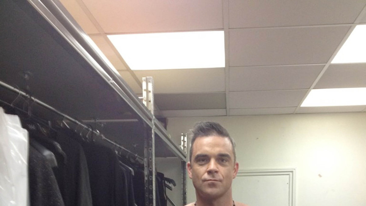 Robbie Williams visar var skåpet ska stå.