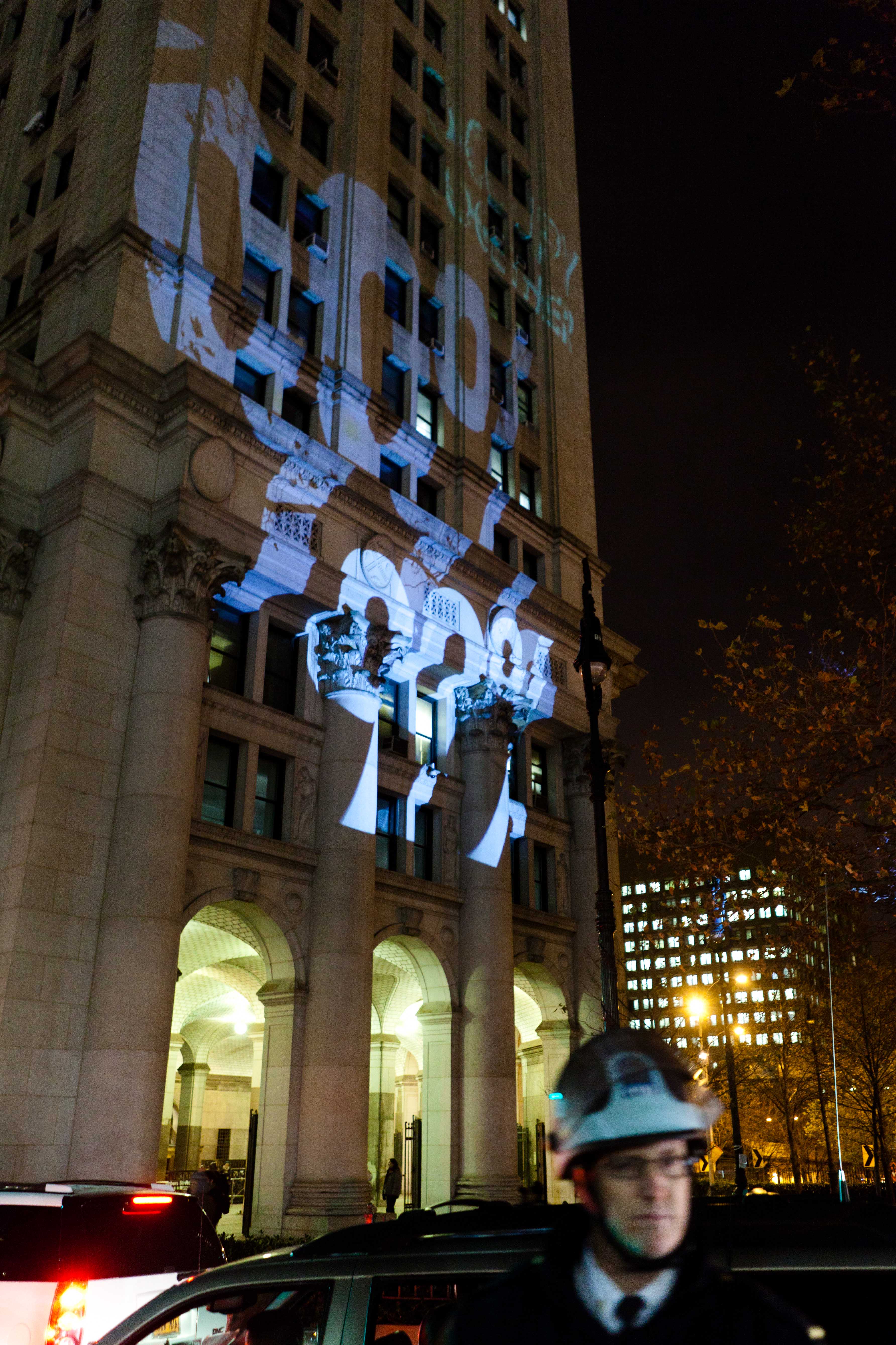 Occupy Wall Street projekterar ett "99%" tecken på sidan av Manhattans stadshus.