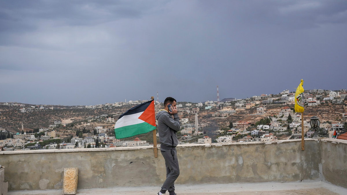 En man med den palestinska flaggan i en by på Västbanken i november 2023.