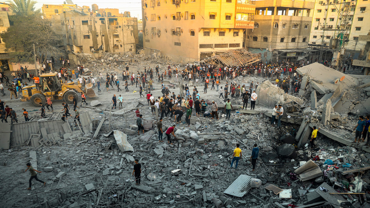 Människor söker efter överlevande efter ett israeliskt luftangrepp i Rafah på Gazaremsan på tisdagen.