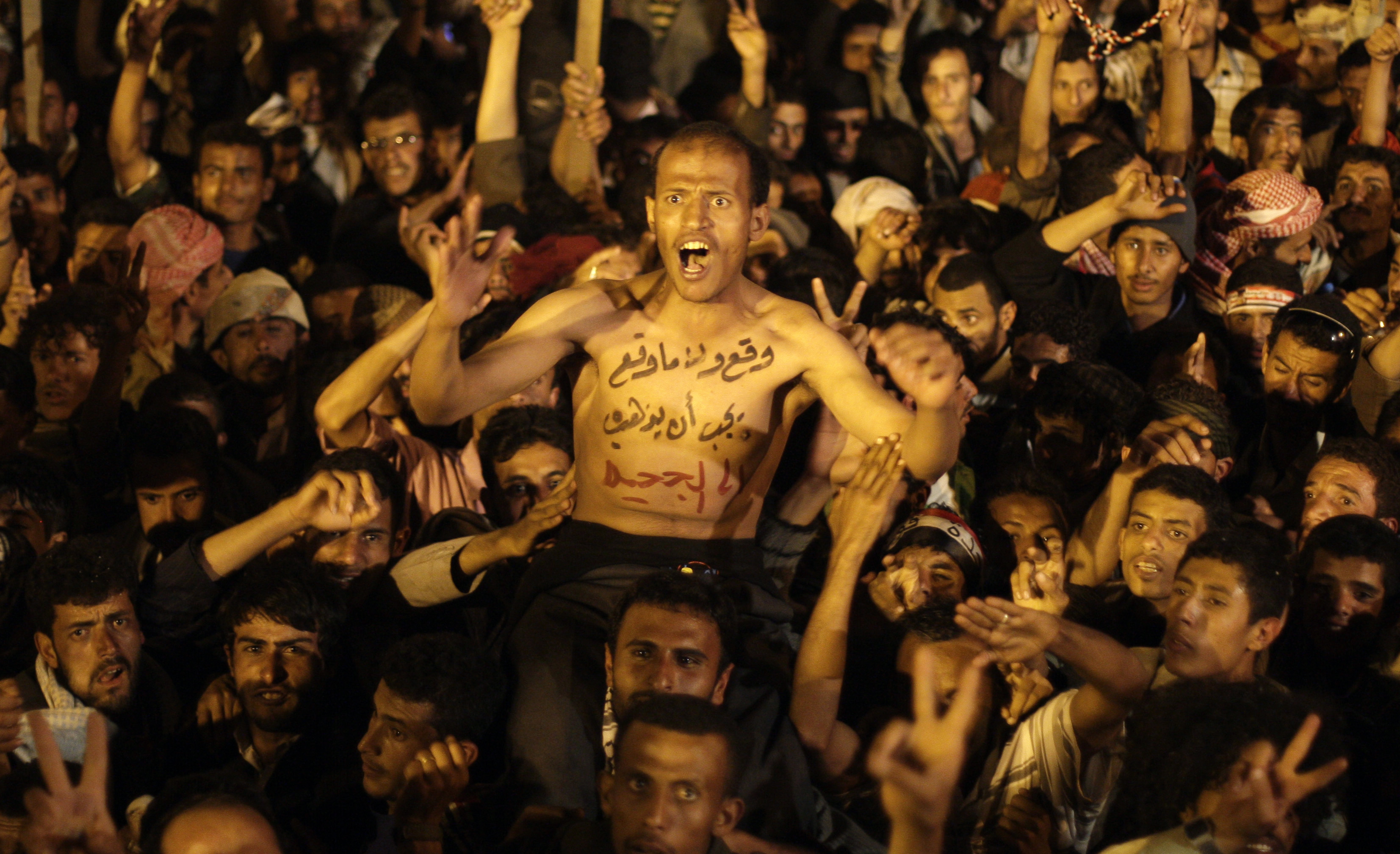 Demonstrationer i Sanaa. På mannens bröst står det "vare sig han skrev på eller ej måste han dra åt helvete".