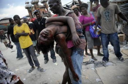 20/1/2010. Fabienne Cherisma, 15, letade efter något att ta med hem till mamma och pappa under de plundringståg för överlevnad som härjade Port-au-Prince. Kanske dagens sista trofé. Hon skjuts och dödas av av hatisk polis. Hennes pappa bär hem hennes krop