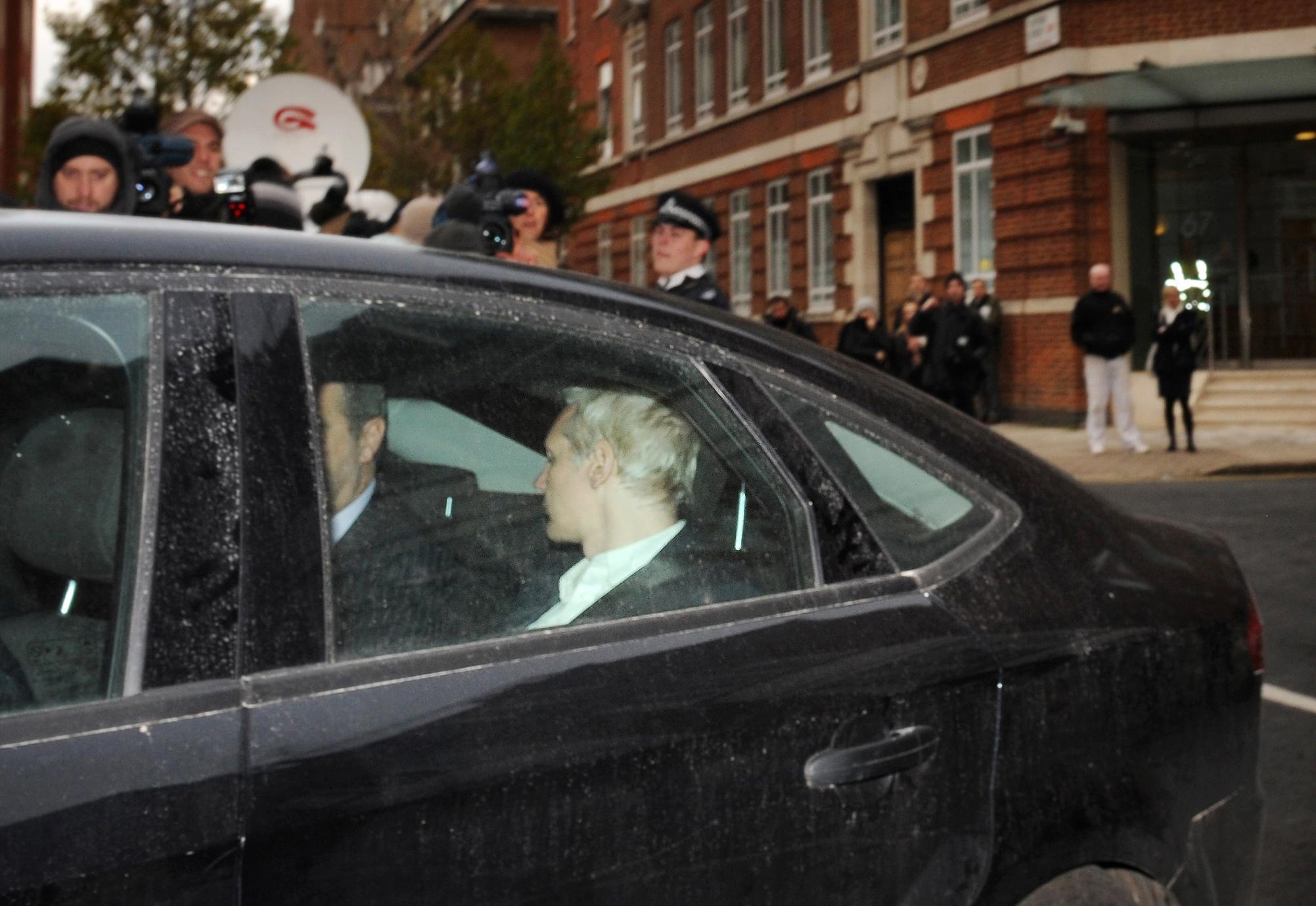 Assange inställer sig hos polisen inför ett enormt medieuppbåd.