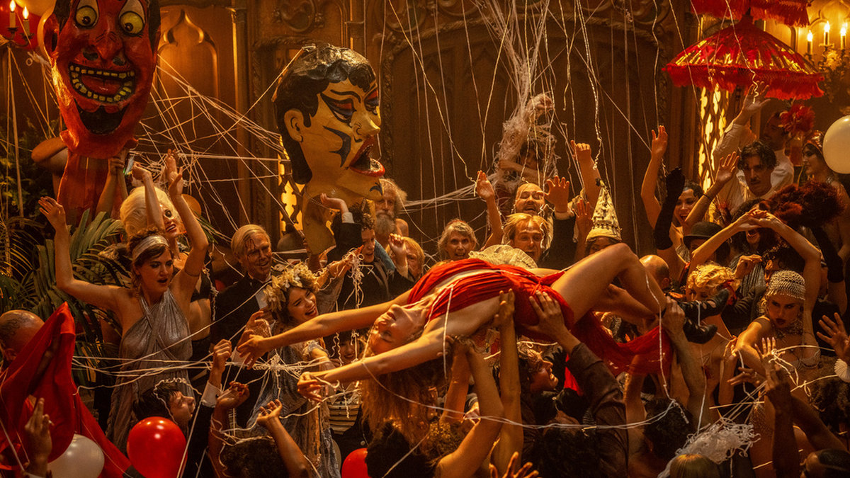Margot Robbie bärs runt under en av de storslagna festscenerna i 'Babylon'. Pressbild.