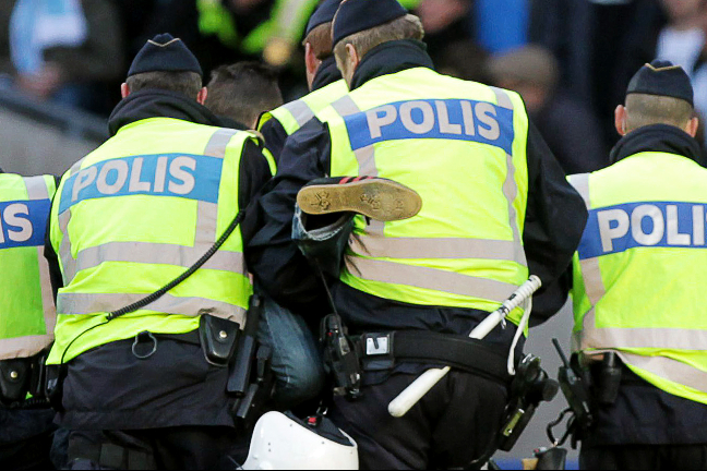 Här bärs den 18-årige svenske huliganen ut av poliser efter 