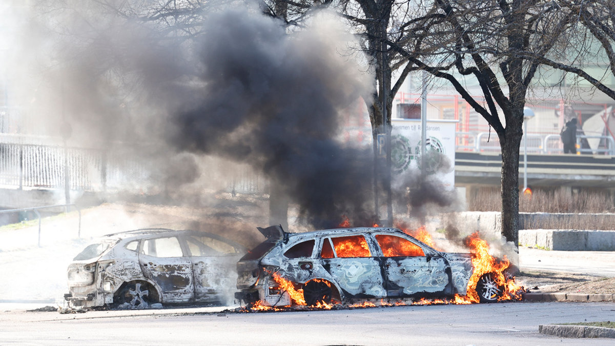 Två bilar i brand på en parkering vid Ringdansen centrum, i samband med upplopp i Navestad i Norrköping på påskdagen.