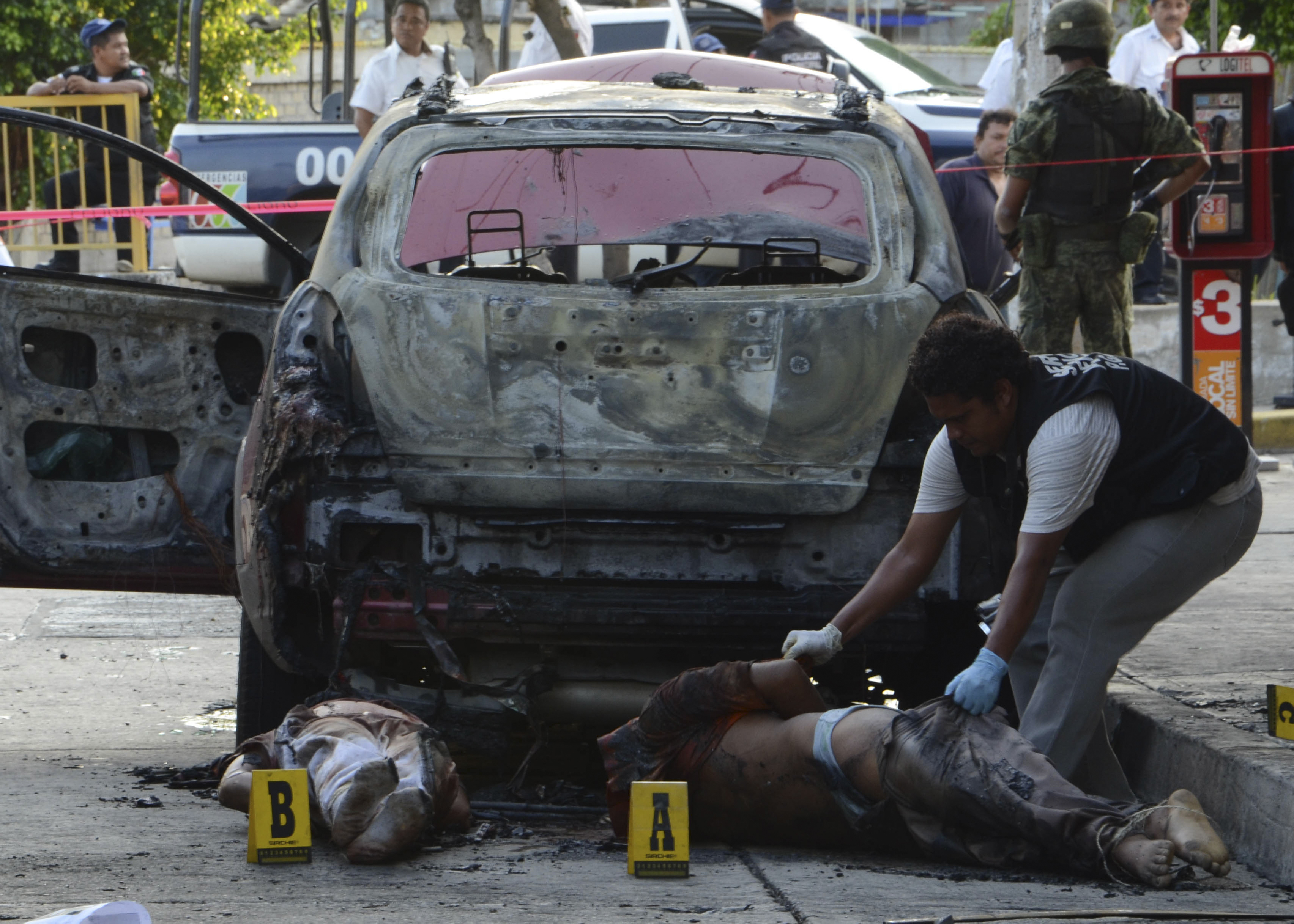 Kriminaltekniker undersöker döda vid semesterorten  Acapulco i september 2011.