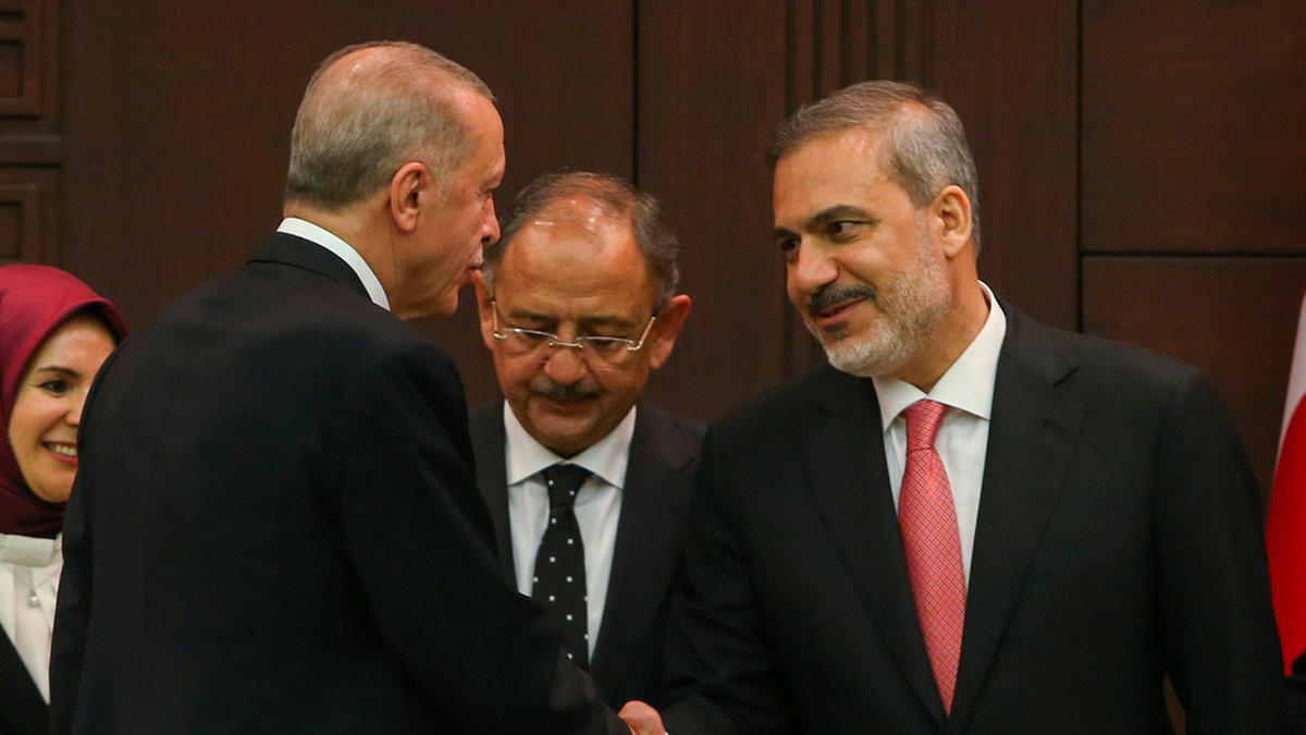 President Recep Tayyip Erdogan skakar hand med den nye utrikesminister Hakan Fidan i samband med att den nya regeringen presenterades i lördags. Arkivbild.