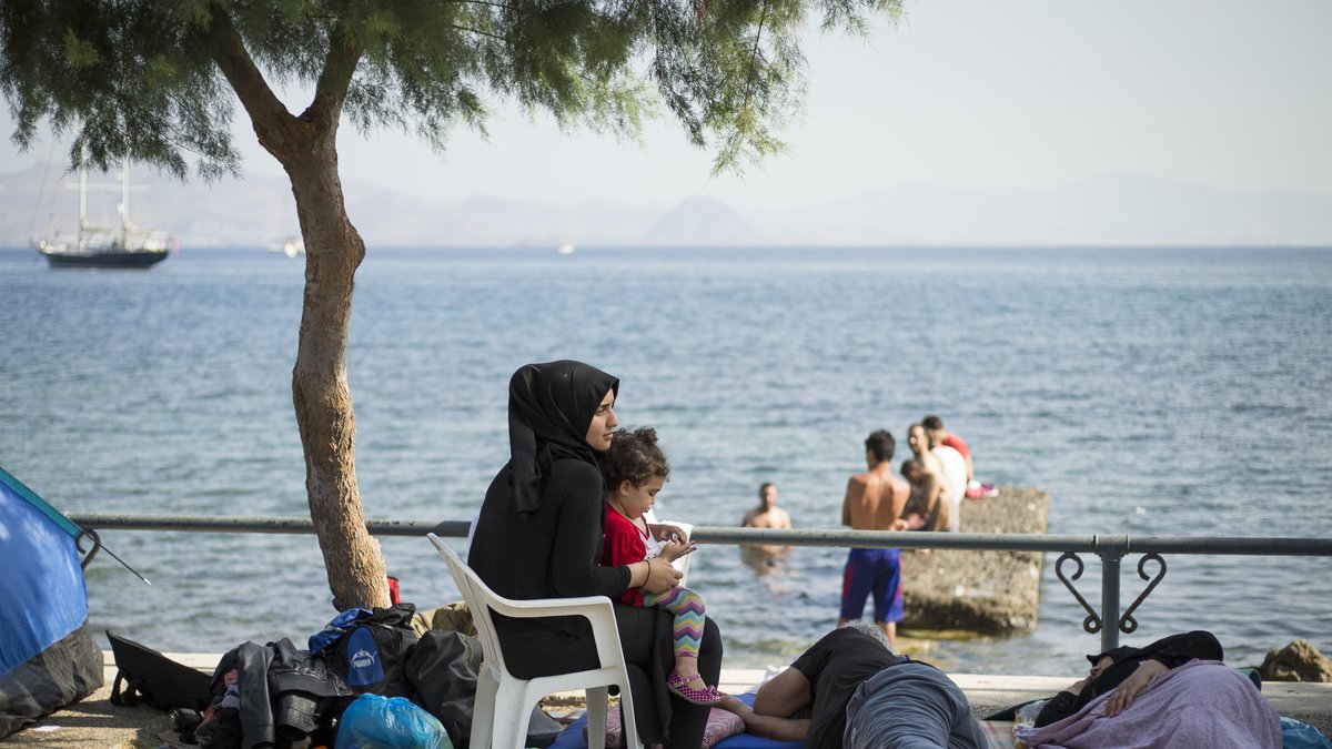 Kontrasten i Kos – flyktingar har slagit läger och i närheten dricker turister drinkar. 