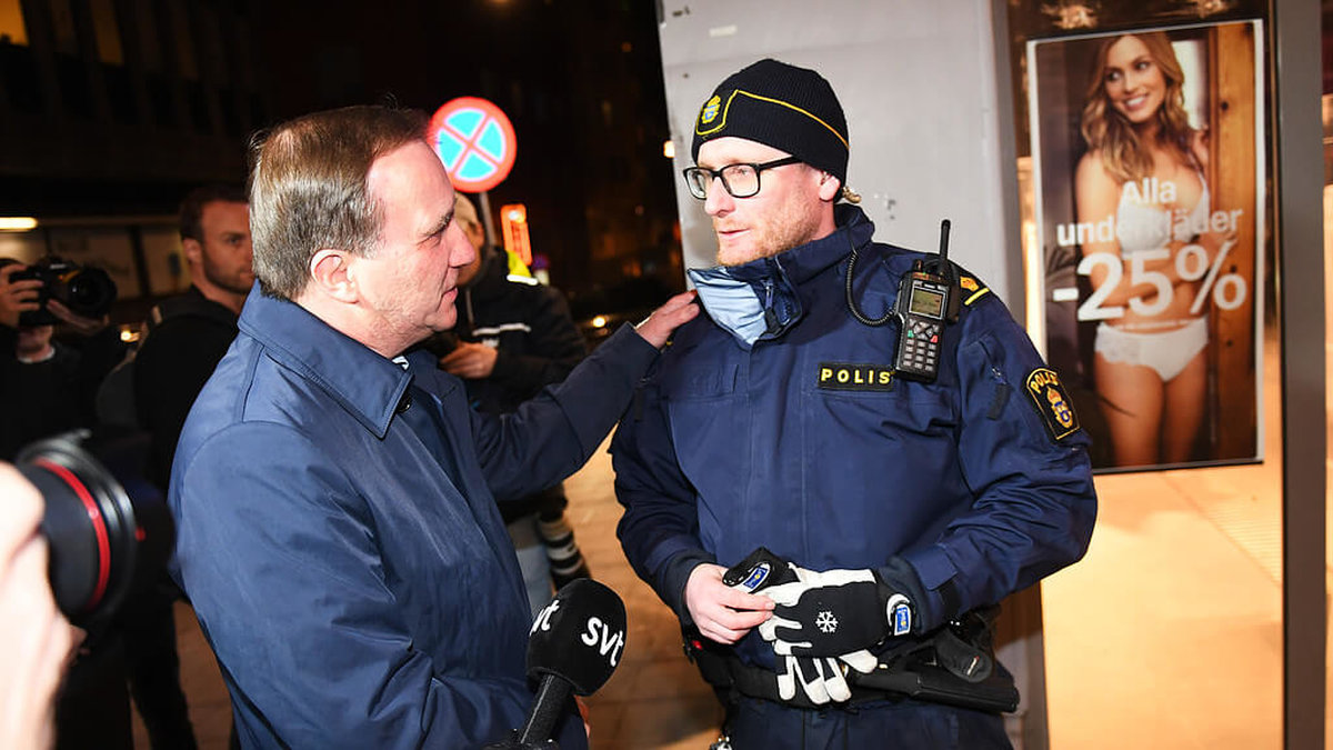 Statsminister Stefan Löfven tackar polisen Jonas Hvitfeldt vid olycksplatsen på Drottningatan i Stockholm.