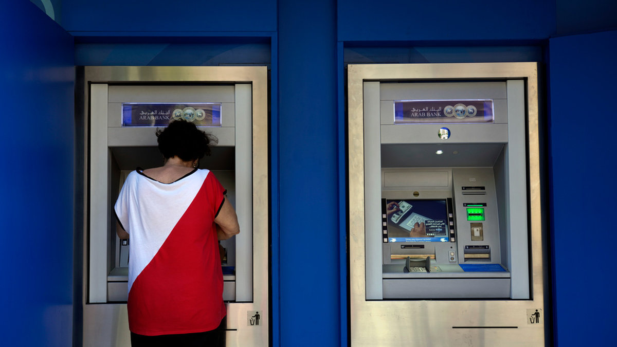 En kvinna tar ut pengar i en bankomat i Beirut tidigare i september.