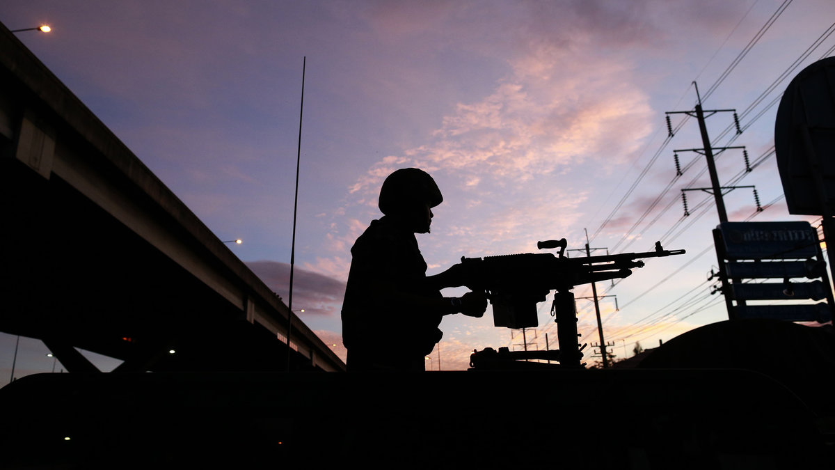 En soldat bemannar sitt maskingevär på ett militärfordon utanför Centre for the Administration of Peace and Order (CAPO). Efter att soldater skickats för att belägra centret. 