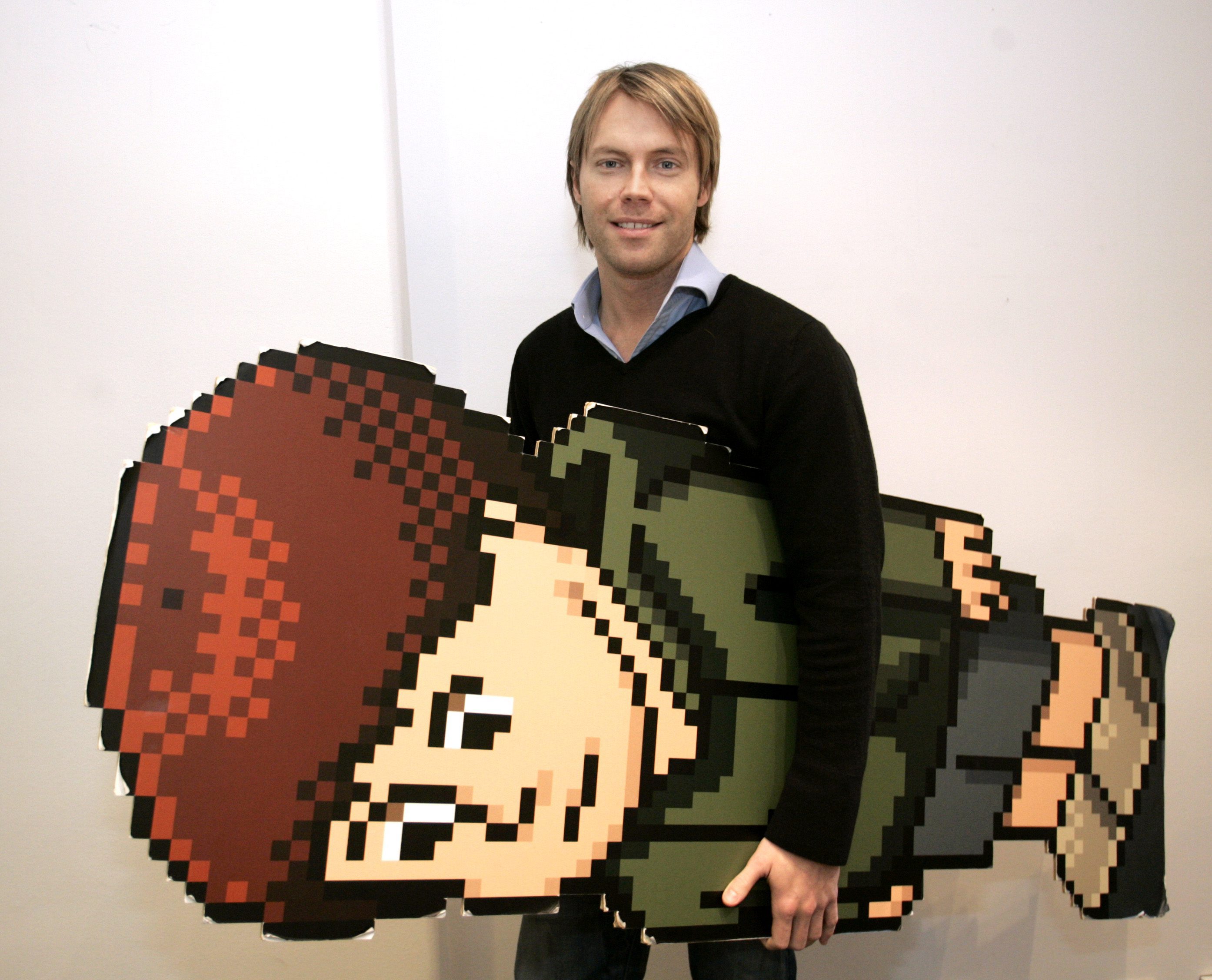 Björn Gent, verksamhetschef för Habbo i Sverige, poserar med en Habbo-avatar i stort format.