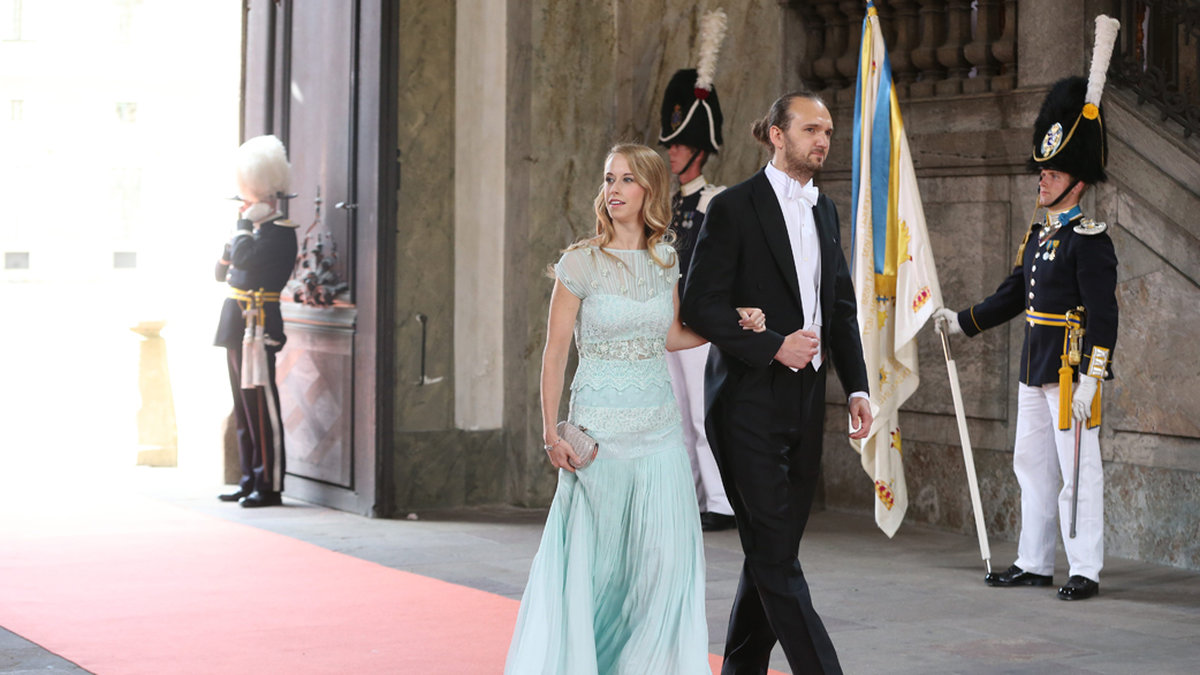 Sofias syster Sara Hellqvist bar en pastellblå klänning och anlände med den fortfarande något obekväma Oskar Bergman.