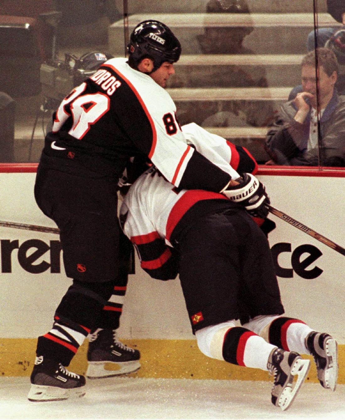 Dackell blir mosad av Philadelphia Flyers-tuffingen Eric Lindros under en match i oktober 1998.