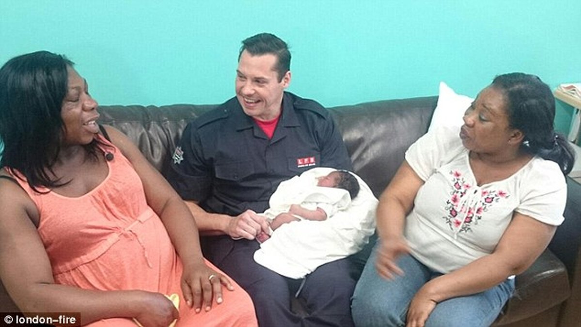 Här sitter han med den lilla bebisen som ska heta Jamie och hennes mamma Richlove Agyei. 