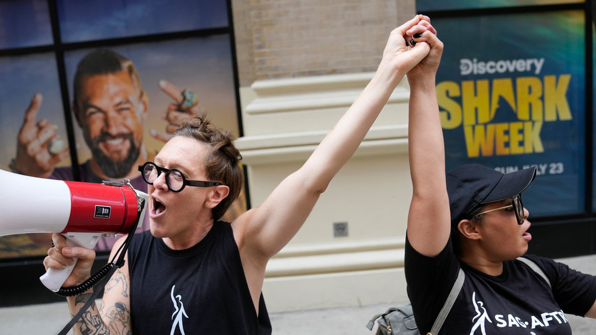 Strejkande manusförfattare och skådespelare sjunger ut sina protester i New York.