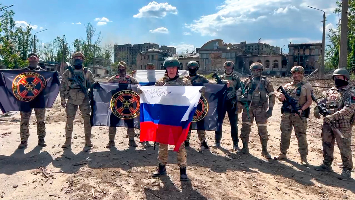 Jevgenij Prigozjin, som håller den ryska flaggan, poserar med soldater i Bachmut. Bilden distribuerades den 20 maj. Arkivbild.