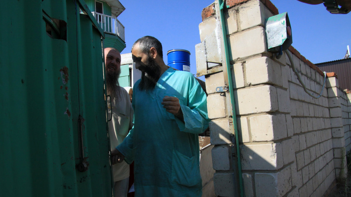 En medlem ur den underjordiska sekten står framför ingången till sektledarens hus i Tatarstan.