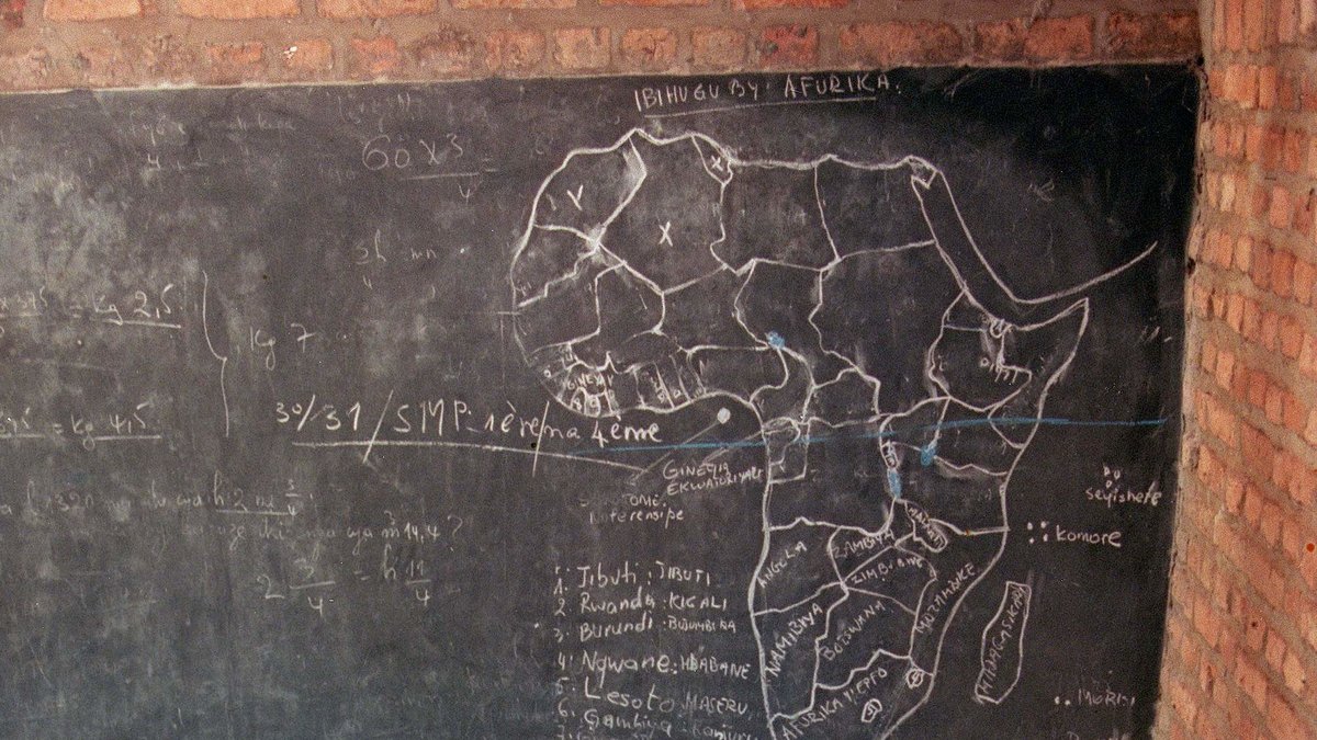 Det här är maj 1994 i Rwandas huvudstad. En lärare har slaktats och lagts under målningen av Afrika på svarta tavlan.