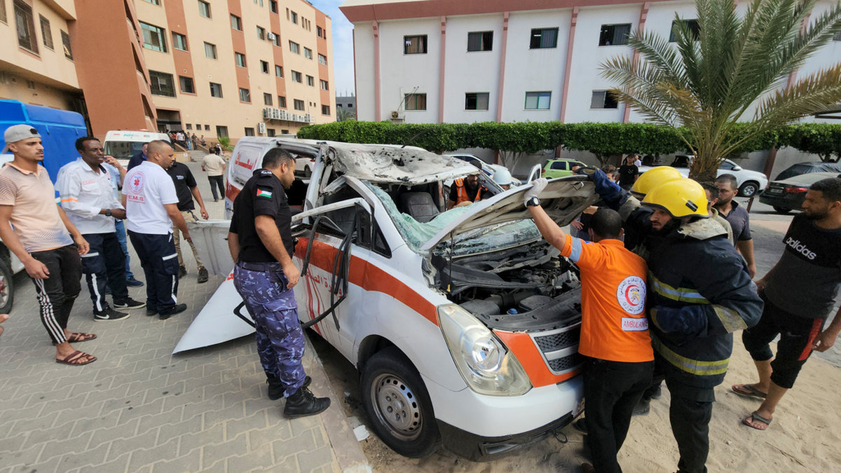 Sjukvårdspersonal inspekterar en skadad ambulans som träffades i ett israeliskt flyganfall förra veckan.