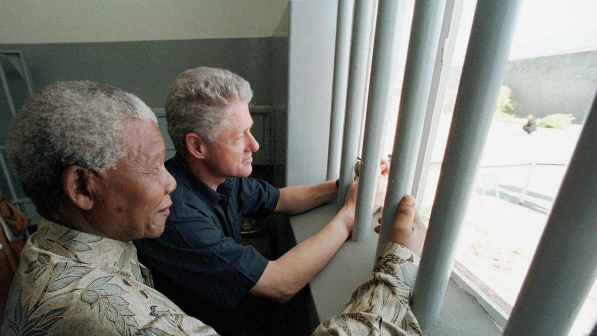 Nelson Mandela blickar tillsammans med Bill Clinton ut från fängelsecellen på Robben Island.