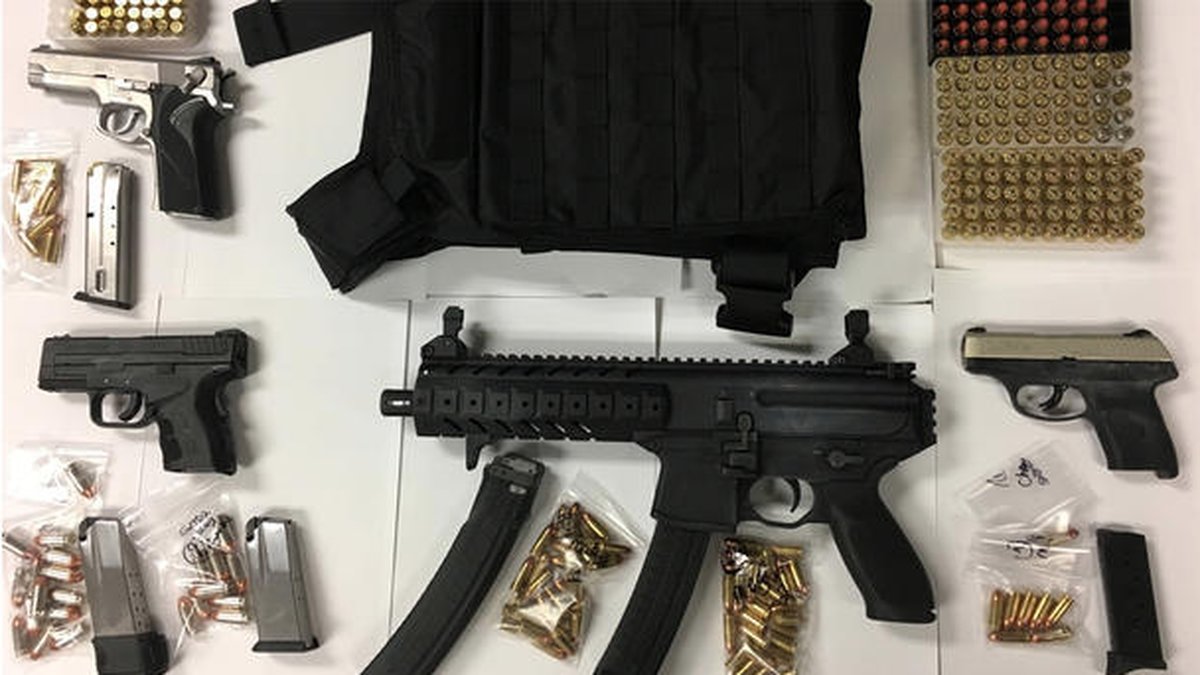 Tre handvapen och ett halvautomatiskt gevär, en skottsäker väst, ammunition och två påsar med marijuana​ hittades i bilen.