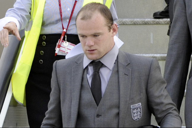 En betydligt mer städad Rooney anländer efter fiaskot i VM.